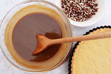 Image showing Making pecan pie - stirring the filling with a wooden spoon