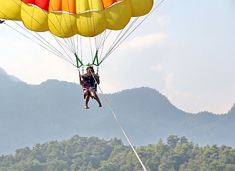 Image showing Parasailing in a blue sky near sea beach