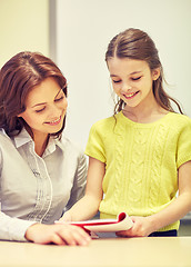 Image showing school girl with notebook and teacher in classroom