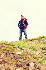 Image showing tourist with beard and backpack raising hands