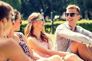 Image showing group of smiling friends outdoors sitting in park
