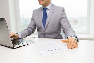 Image showing close up of businessman with laptop and papers