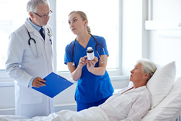 Image showing doctor giving medicine to senior woman at hospital