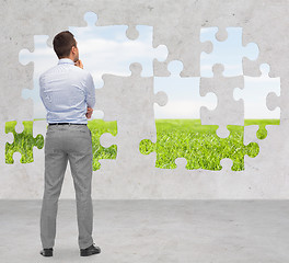 Image showing businessman over puzzle with natural landscape