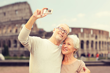 Image showing senior couple photographing over coliseum