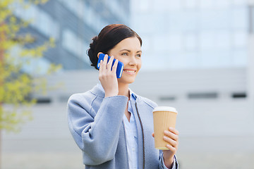 Image showing smiling woman with coffee calling on smartphone