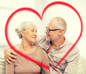 Image showing happy senior couple hugging on sofa at home