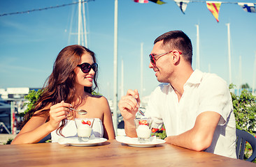 Image showing smiling couple eating dessert at cafe