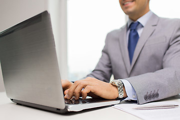 Image showing close up of businessman with laptop and papers