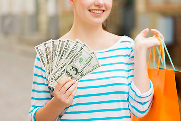 Image showing close up of woman with shopping bags and money