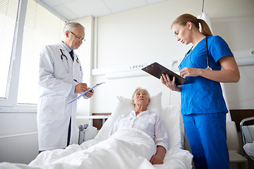 Image showing doctor and nurse visiting senior woman at hospital