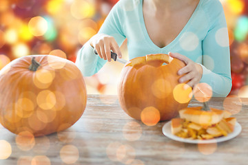Image showing close up of woman carving pumpkins for halloween