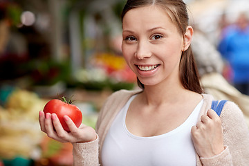 Image showing happy woman holding tomato at street market