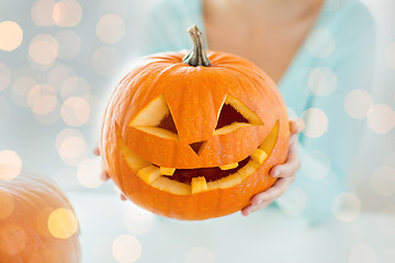Image showing close up of woman holding carved halloween pumpkin