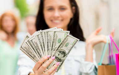 Image showing close up of woman with shopping bags and money