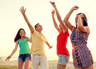 Image showing smiling friends dancing on summer beach