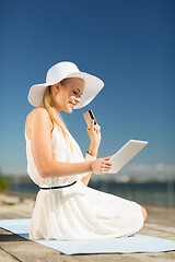 Image showing woman in hat doing online shopping outdoors