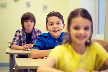 Image showing group of school kids with notebooks in classroom