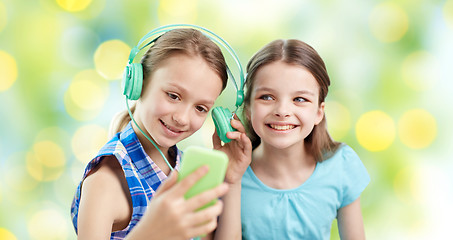 Image showing happy girls with smartphone and headphones