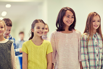 Image showing group of smiling school kids walking in corridor