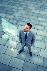 Image showing smiling businessman with chart outdoors from top