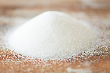 Image showing close up of white sugar heap on wooden table