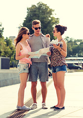 Image showing smiling friends with map and city guide outdoors