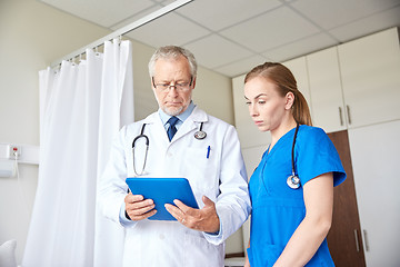Image showing senior doctor and nurse with tablet pc at hospital