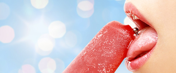 Image showing woman with pierced tongue licking fruit ice cream