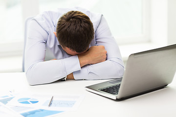 Image showing businessman with laptop and papers in office