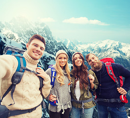 Image showing group of smiling friends with backpacks hiking