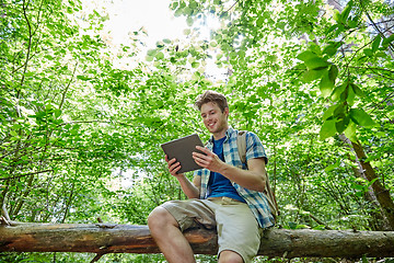 Image showing happy man with backpack and tablet pc in woods