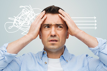 Image showing unhappy man with closed eyes touching his forehead