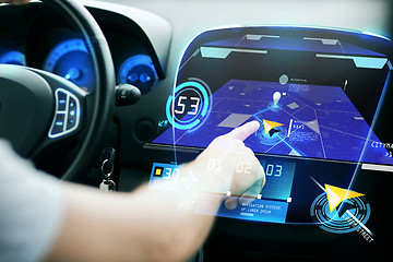 Image showing male hand using navigation system on car dashboard