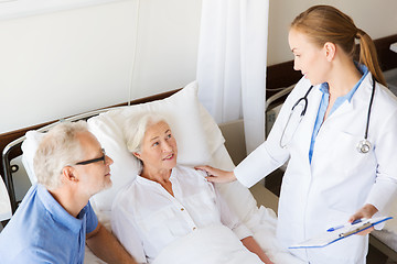 Image showing senior woman and doctor with clipboard at hospital