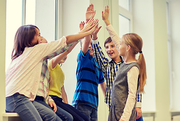 Image showing group of smiling school kids making high five