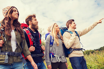 Image showing group of smiling friends with backpacks hiking