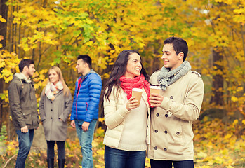 Image showing group of smiling friend with coffee cups in park