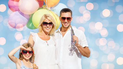 Image showing happy family with balloons over blue lights