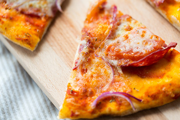 Image showing close up of homemade pizza slice on wooden table