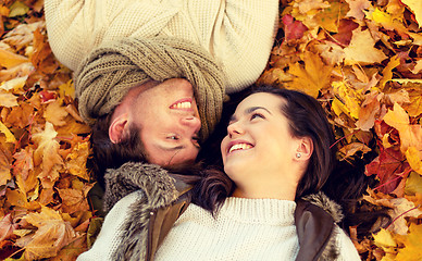 Image showing close up of smiling couple lying in autumn park