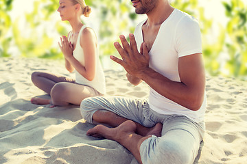 Image showing smiling couple making yoga exercises outdoors