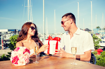 Image showing smiling couple with gift box cafe