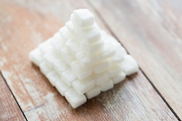 Image showing close up of white sugar pyramid on wooden table