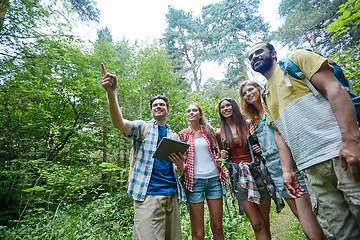 Image showing happy friends with backpacks and tablet pc hiking