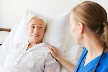 Image showing doctor or nurse visiting senior woman at hospital