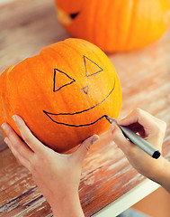 Image showing close up of woman with pumpkins at home