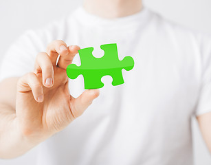 Image showing close up of man holding green puzzle piece