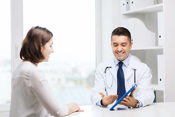 Image showing smiling doctor and woman with tablet pc at clinic