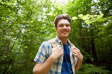 Image showing smiling young man with backpack hiking in woods
